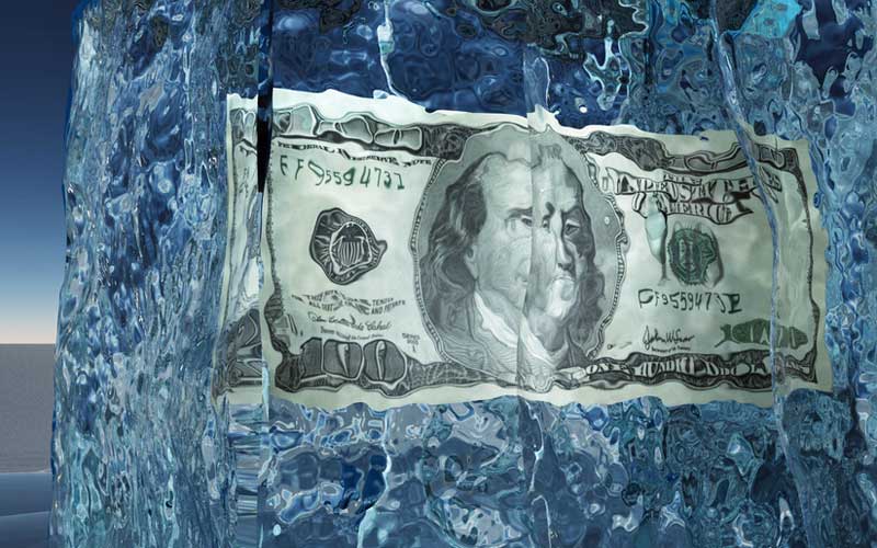 Dollar frozen in ice to illustrate lack of NFT liquidity